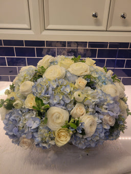 arrangement with blue hydrangea white roses , ranunculus and tweedia