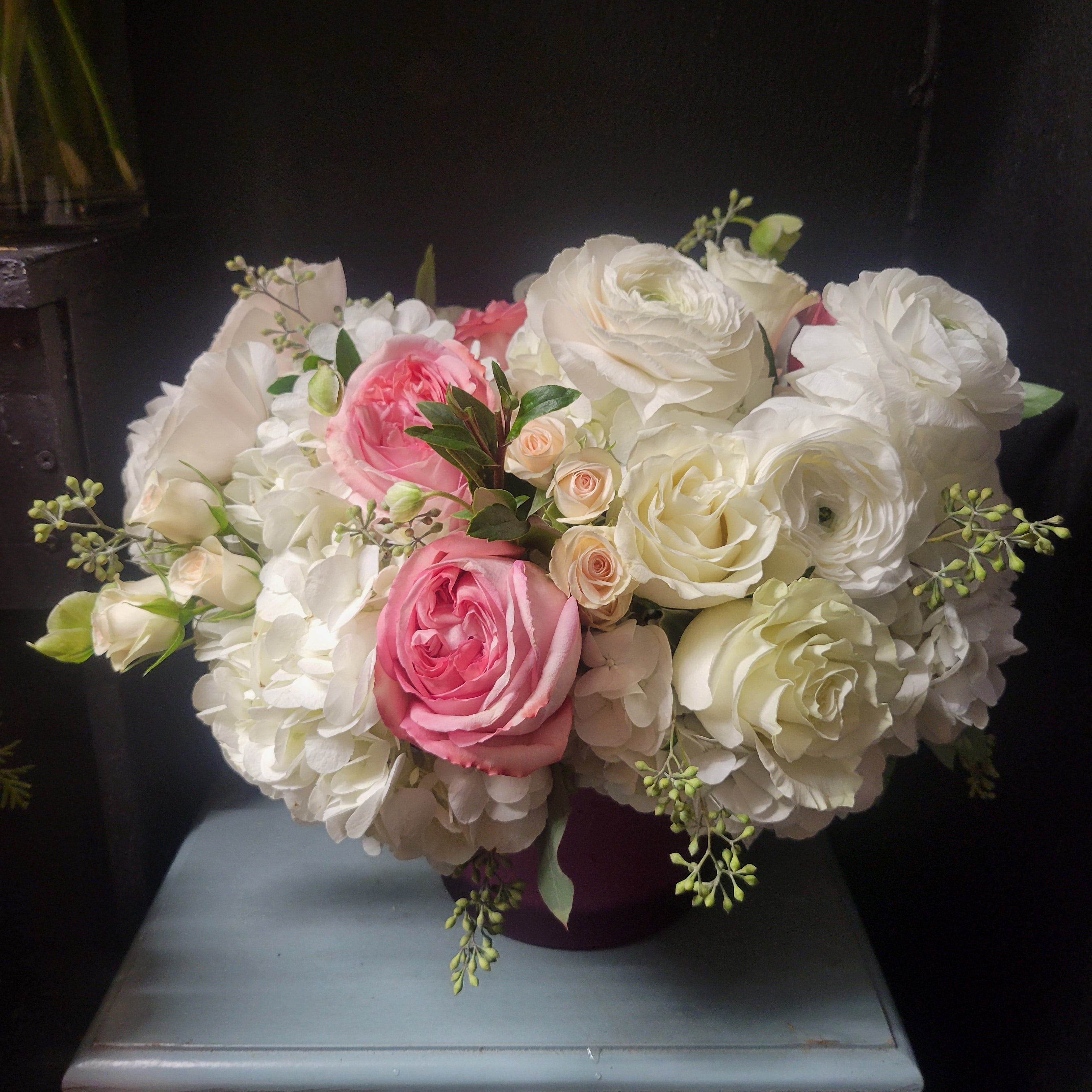 arrangement with white hydrangea, spray roses garden roses , white roses , hellebore and eucalyptus