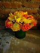 Glass vase with orchid orange roses and protea